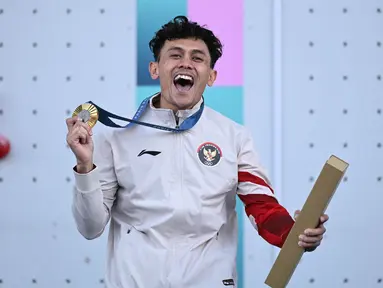 Peraih medali emas dari Indonesia, Veddriq Leonardo, merayakan kemenangannya di atas podium nomor panjat tebing putra dalam ajang panjat tebing nomor kecepatan Olimpiade Paris 2024 di Le Bourget Sport Climbing Venue, Le Bourget, 8 Agustus 2024. (Jonathan NACKSTRAND/AFP)