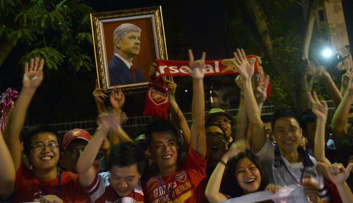 Para suporter Arsenal asal Vietnam menyambut kedatangan pelatih Arsene Wenger di Stadion My Dinh, Hanoi, Sabtu (13/7/2013). (AFP/Hoang Dinh Nam)