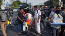 Pedagang melayani pembeli minuman saat berjualan di antara massa aksi di jalan tol dalam kota yang berada di depan Gedung DPR RI, Jakarta, Senin (30/9/2019). Adanya aksi unjuk rasa di sekitar lokasi dimanfaatkan para pedagang asongan untuk mencari rezeki. (Liputan6.com/Immanuel Antonius)