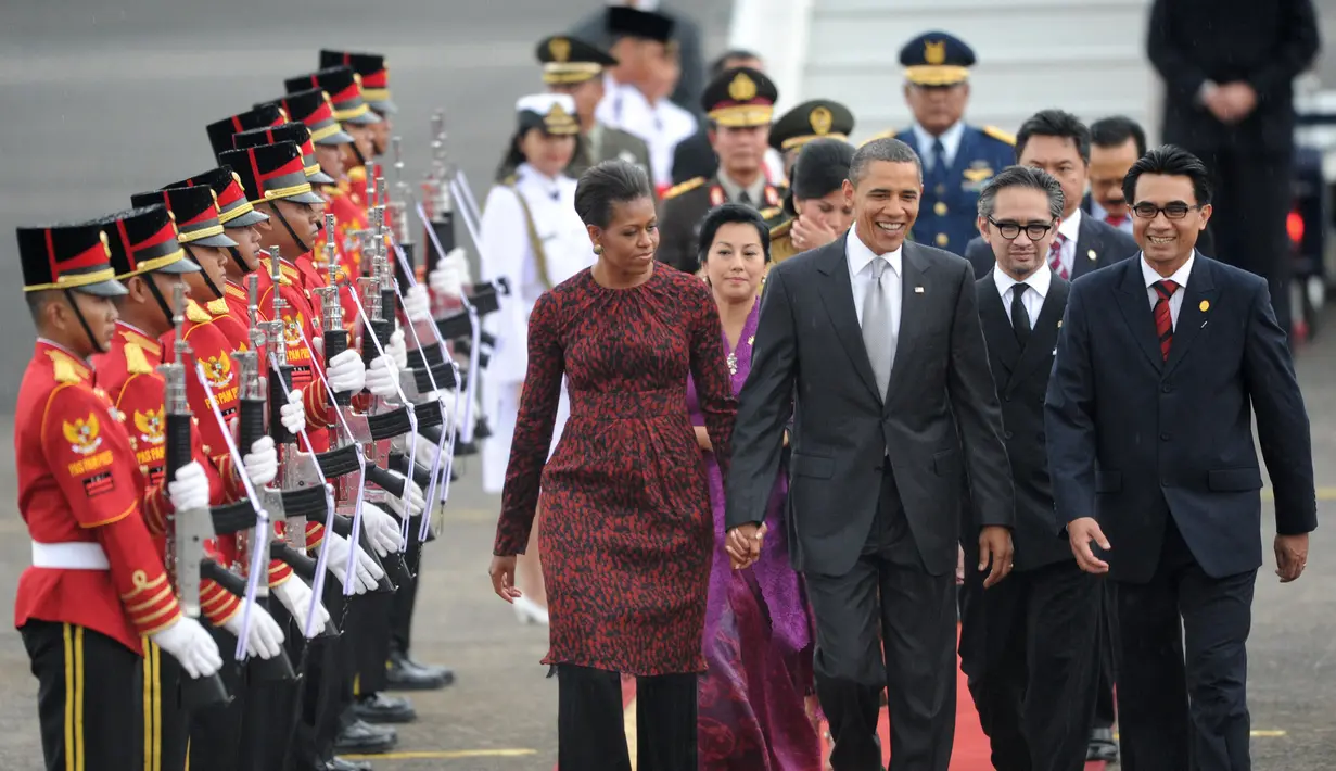 Presiden Amerika Serikat (AS) ke-44, Barack Obama menggandeng tangan sang istri, Michelle Obama, saat berjalan di karpet merah setibanya di Bandara Perdana Kusuma, Jakarta, 9 November 2010. (AFP PHOTO / ROSLAN RAHMAN)