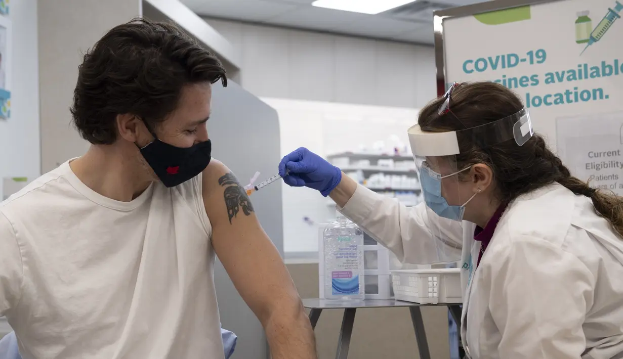 Perdana Menteri Kanada Justin Trudeau (kiri) menerima vaksinasi COVID AstraZeneca pertamanya di Ottawa, Kanada, Jumat (23/4/2021). Vaksinasi Trudeau ini dilakukan di depan sorotan kamera untuk memastikan keamanannya kepada publik. (Adrian Wyld/The Canadian Press via AP)