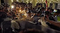 Polisi menyemprotkan merica kepada pengunjuk rasa yang menolak RUU Ekstradisi di luar gedung parlemen, Hong Kong, Senin (10/6/2019). Bentrokan terjadi ketika pengunjuk rasa memaksa masuk ke gedung parlemen di Hong Kong. (AP Photo/Vincent Yu)