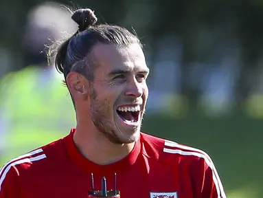 Pemain Timnas Wales, Gareth Bale, tertawa saat mengikuti latihan jelang laga UEFA Nations League di Hensol, South Wales, Senin (31/8/2020). Wales akan berhadapan dengan Finlandia. (AFP/Geoff Caddick)