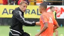 Asisten pelatih Valencia, Phil Neville, memberikan arahan kepada Rodrigo saat pemanasan. (Bola.com/Reza Khomaini)