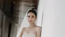 Menikah di awal tahun 2023 dengan Deva Mahendra, Mikha Tambayong tampil elegan dengan gaun putih berpayet model tube milik sang ibunda. Gaun model slit tersebut dipadukan veil panjang. [@mikhatambayong]