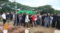 Aktor, Gary Iskak meninggal dunia pada Sabtu 29 November 2025, akibat kecelakaan sepeda motor. Tampak dalam foto, sejumlah kerabat dan pelayat menggotong jenazah Gary Iskak di Taman Pemakaman Umum (TPU) Tanah Kusir, Jakarta Selatan, Sabtu (29/11/2025). (Kapanlagi.com/Budy Santoso)