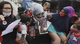 Perempuan dan anak-anak menaiki mobil bak terbuka untuk dievakuasi dari rumah mereka di lereng Gunung Merapi, di Krinjing, Jawa Tengah, Jumat (6/11/2020). Evakuasi dilakukan bagi warga lereng Merapi menyusul peningkatan status aktivitas vulkanik gunung tersebut. (AP Photo/Taufiq Rozzaq)