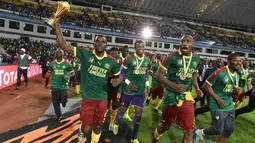 Bek Kamerun, Michael Ngadeu-Ngadjui mengangkat piala saat merayakan kemenangan atas Mesir pada laga final Piala Afrika 2017 di Stade de I'Amitie, Gabon, Minggu (5/2). Kamerun meraih gelar kelima Piala Afrika usai menang 2-1 atas Mesir. (ISSOUF SANOGO/AFP)