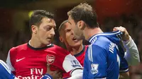 Gelandang Arsenal, Mesut Oezil berdebat dengan bek Chelsea, Branislav Ivanovic pada laga Liga Inggris musim 2013/14 di Emirate Stadium, Inggris, Senin (23/12/2013). (EPA/Gerry Penny)