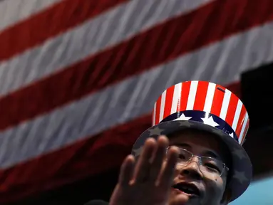 Seorang pria mengenakan topi bermotif bendera Amerika Serikat saat menonton siaran langsung pemilihan presiden AS yang digelar di Kedutaan Besar AS di Beijing, Rabu (9/11). (AP Photo / Andy Wong)