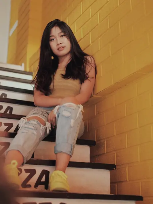 Menggunakan ripped jeans yang dipadukan dengan kaos berwarna kuning. Penampilan wanita yang akrab disapa Della terlihat colorfull dan trendi. (Liputan6.com/IG/@awdella)