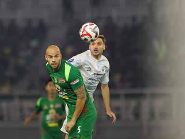 Pemain Persebaya, Risto Mitrevski berduel dengan pemain PSIM Yogyakarta, Nermin Haljeta pada pertandingan pembuka BRI Super League 2025/2026 di Stadion Gelora Bung Tomo, Jumat (08/08/2025) malam WIB. (Bola.com/Abdul Aziz)
