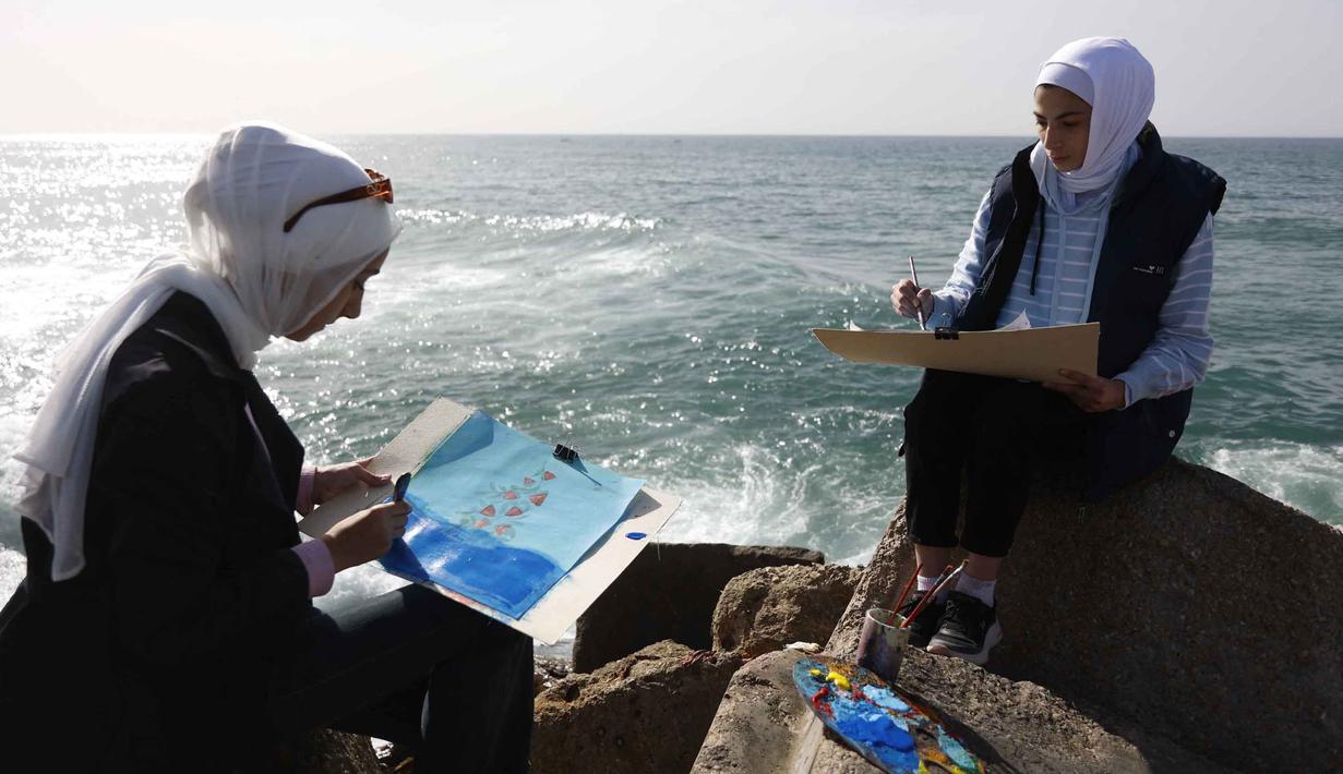 Lokakarya ini berfokus pada pemulihan psikologis bagi anak perempuan dan pemuda di Gaza. Tampak dalam foto, para perempuan muda melukis di pelabuhan Kota Gaza pada Kamis 12 Februari 2026. (Omar AL-QATTAA/AFP)