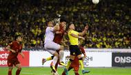Penyerang Timnas Darren Lok (kuning) berduel di udara dengan kiper dan pemain belakang Timnas Thailand dalam laga semifinal leg pertama Piala AFF 2022, Sabtu (7/1/2023) di Stadion Bukit Jalil. (Dok. FA Malaysia)