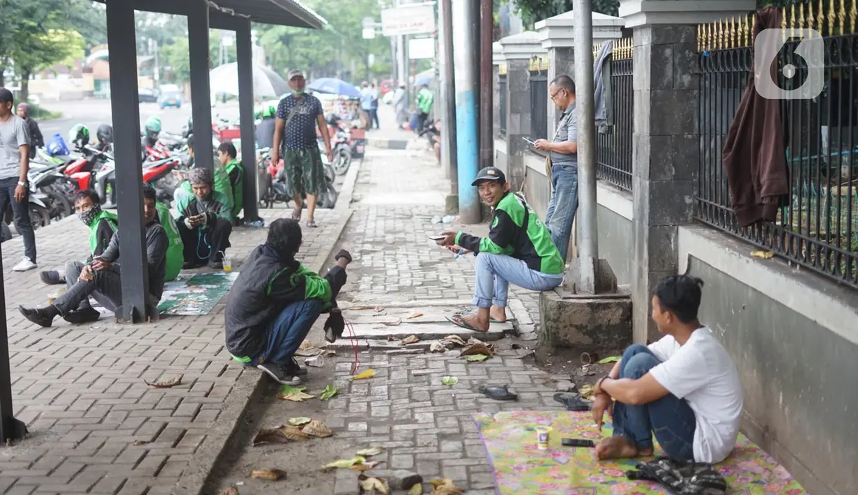 Pengemudi ojek daring menunggu order di depan Cibubur Junction, Jakarta, Selasa (24/3/2020). Merebaknya corona Covid-19 menyebabkan aktivitas di kawasan itu lesu yang juga berimbas pada turunnya pendapatan pengemudi ojol hingga lima kali lipat dibanding hari biasanya (Liputan6.com/Immanuel Antonius)