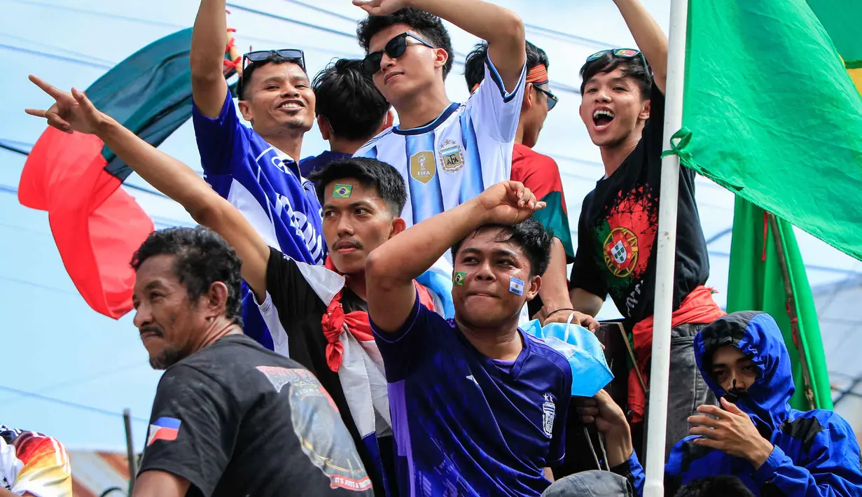 Penggemar sepak bola berpartisipasi dalam konvoi menyambut turnamen sepak bola Piala Dunia 2026 di Polewali Mandar, Sulawesi Barat, Kamis 11 Juni 2026. (Muhammad SALIM/AFP)