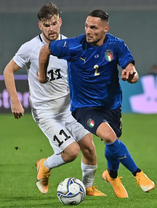 Bek Italia, Danilo D’Ambrosio (Kanan) berebut bola dengan gelandang Estonia Frank Liivak dalam laga uji coba internasional di Artemio Franchi, Kamis (12/11/2020) dini hari. Italia tanpa kesulitan mengalahkan Estonia dengan skor 4-0. (Alberto PIZZOLI/AFP)