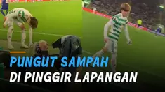 Seorang pemain bola memungut sampah yang berada di pinggir lapangan.