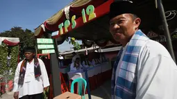 Petugas TPS mengenakan baju khas ala betawi siap menyambut warga yang akan menggunakan hak pilihnya dalam Pilkada Serentak di TPS Kampung Pilkada RW 03, Depok, Jawa Barat, Rabu (9/12). (Liputan6.com/Immanuel Antonius)