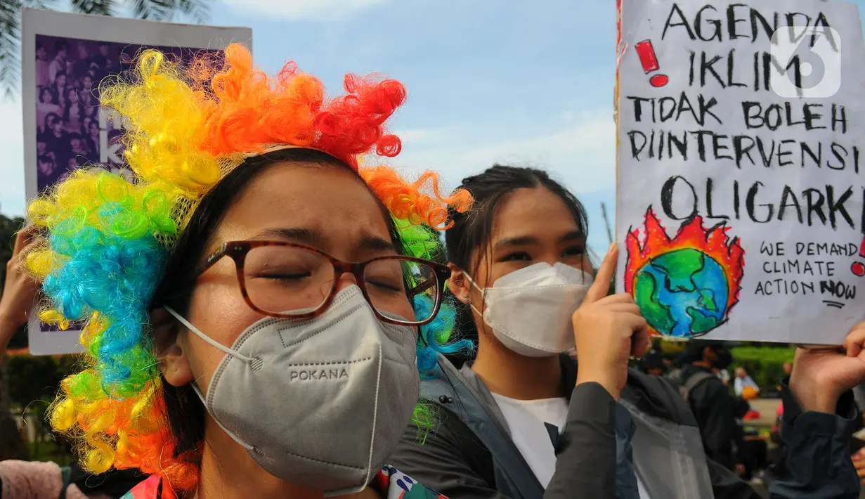 Massa aktivis lingkungan hidup melakukan protes di Kawasan Monas, Jakarta, Jumat, (3/3/2023). Aksi ini juga menuntut  untuk menghentikan proyek-proyek solusi palsu yang membawa  Indonesia tetap terjebak pada candu energi fosil batubara.  (merdeka.com/Imam Buhori)