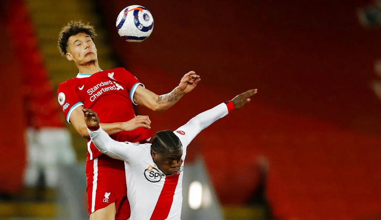 Pemain Liverpool, Rhys Williams, duel udara dengan pemain Southampton, Michael Obafemi, pada laga Liga Inggris di Stadion Anfield, Minggu (9/5/2021). Liverpool menang dengan skor 2-0. (Phil Noble/Pool via AP)