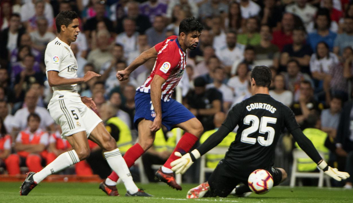 Striker Atletico Madrid, Diego Costa, berusaha membobol kiper Real Madrid, Thibaut Courtois, pada laga La liga di Stadion Santiago Bernabeu, Madrid, Sabtu (29/9/2018). Kedua klub bermain imbang 0-0. (AFP/Curto De La Torre)