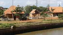 Pemandangan proyek pembangunan Perkampungan Budaya Betawi di tengah Setu Babakan, Jakarta, Kamis (3/1). Kawasan tersebut nantinya akan dihiasi dengan berbagai bangunan bertema Betawi. (Liputan6.com/Immanuel Antonius)