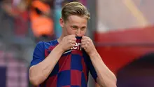Gelandang asal Belanda Frenkie de Jong mencium logo klub barunya saat pengenalan dirinya sebagai pemain Barcelona di stadion Camp Nou, Spanyol (5/7/2019). Frenkie de Jong sangat antusias bisa bermain dengan sang superstar, Lionel Messi. (AFP Photo/Lluis Gene)