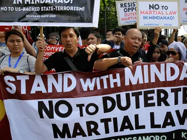 Sejumlah orang menggelar aksi menentang deklarasi darurat militer di depan Gedung DPR Filipina, Manila, Rabu (31/5). Mereka menolak deklarasi darurat militer di Mindanao yang diumumkan Duterte pada pertengahan Juli 2017. (AP Photo / Aaron Favila)