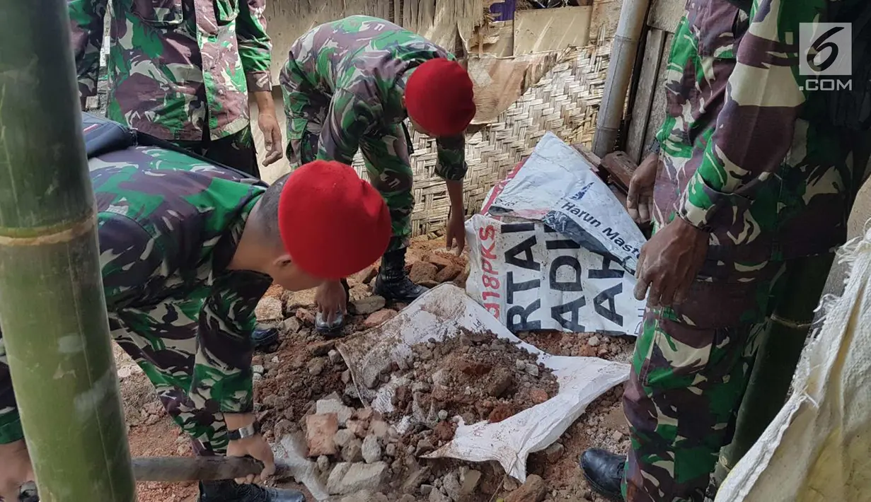 Prajurit Kopassus membersihkan puing-puing bangunan yang ambruk di Desa Citalahap, Kabupaten Lebak, Bogor (23/1). Wilayah tersebut merupakan satu lokasi terparah terkena dampak gempa. (LIputan6.com/Pool/Kopassus)