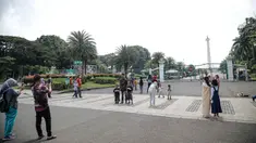Warga berfoto di halaman luar Monumen Nasional (Monas) Jakarta, Kamis (5/5/2022). Meski kawasan Monas masih ditutup sejak awal pandemi COVID-19 pada Maret 2020 lalu namun tidak menyurutkan minat warga untuk bisa berwisata yaitu dengan memanfaatkan kawasan luar monumen tersebut. (Liputan6.com/Faizal Fanani)