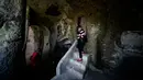 Wisatawan berjalan di pemukiman troglodyte, Kota Matera, Italia, 19 Oktober 2018. Sebelum mendapat pujian dari seluruh dunia, Matera pernah disebut sebagai kota miskin di Italia. (Filippo MONTEFORTE/AFP)