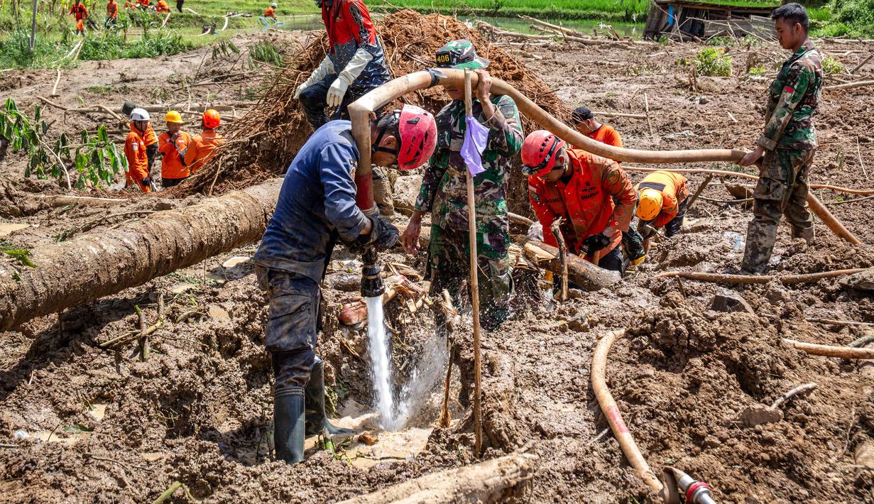 Operasi pencarian juga dihadapkan pada berbagai kendala seperti jalan licin, tertutup lumpur, dan cuaca berkabut yang mengganggu jarak pandang. Tampak dalam foto, petugas penyelamat menggunakan selang bertekanan tinggi untuk menyemprotkan air selama operasi penyelamatan di lokasi longsor di Desa Situkung, Banjarnegara, Jawa Tengah, pada Rabu 19 November 2025. (DEVI RAHMAN/AFP)