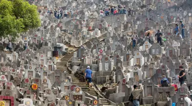 Warga mengunjungi makam keluarga dan kerabat selama festival Qingming di pemakaman di Hong Kong (5/4). Festival Qingming atau dikenal sebagai Hari Pembersihan Makam untuk menghormati orang yang dicintainya yang telah tiada. (AFP Photo/Isaac Lawrence)