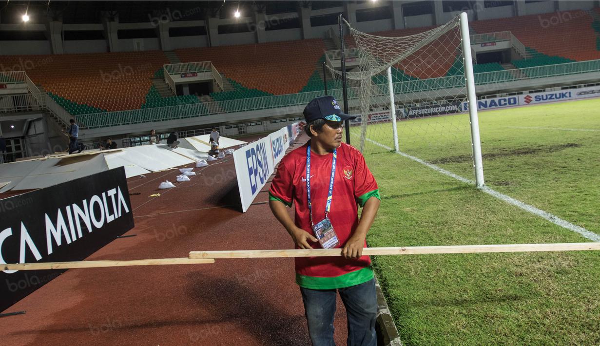 Pekerja mengukur pembatas saat persiapan jelang laga semifinal Piala AFF 2016 antara Timnas Indonesia melawan Vietnam di Stadion Pakansari, Jawa Barat, Jumat (3/12/2016). (Bola.com/Vitalis Yogi Trisna)