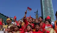 Seorang murid sekolah minggu Gereja Eban Haezer mengenakan baju adat sambil melambaikan bendera nasional di Bundaran HI Jakarta, Minggu (21/8). Menyanyikan lagu Indonesia Raya dan lagu daerah, mereka memperingati HUT RI ke 71. (Liputan6.com/Angga Yuniar)