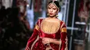 Model berjalan di runway membawakan busana rancangan MNR Design Studio selama Bridal Couture Week di Lahore, Minggu (9/12). Mereka memperagakan kreasi gaun pengantin dari sejumlah desainer ternama di Pakistan. (AP Photo/K.M. Chaudary)