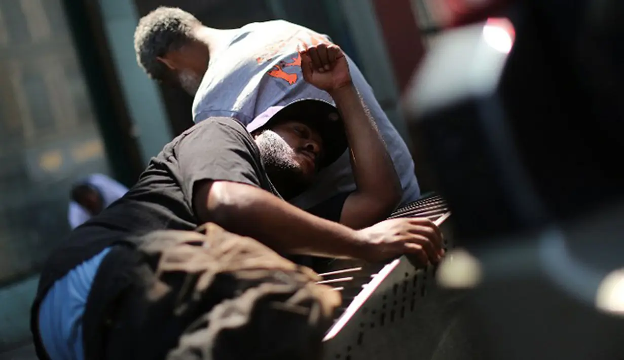 Seorang pria tertidur usai menghisap ganja Sintetis di pinggir jalan East Harlem, New York (5/8/2015). Ganja sintetis memiliki efek yang buruk bagi penggunanya karena merupakan senyawa kimia yang berbahaya. (AFP PHOTO/SPENCER PLATT)