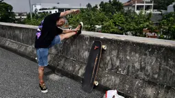 Longboarder dan penderita kanker Nongluck Chairuettichai, juga dikenal sebagai Jeab, melakukan pemanasan sebelum latihan di Bangkok pada 9 September 2020. Kegiatan ini dilakukan Jeab yang berusia 63 tahun sebagai jalan pemulihan dari kanker payudara yang dideritanya. (Lillian SUWANRUMPHA/AFP)