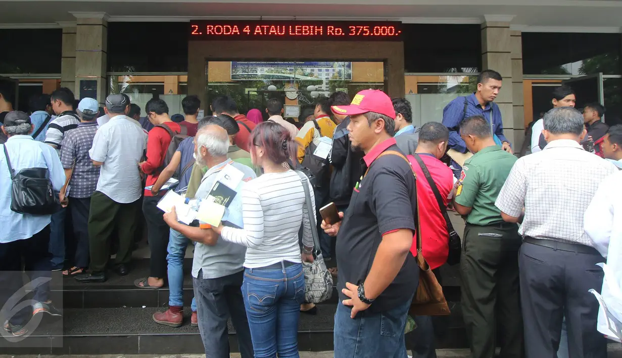 Antrean Warga yang akan mengurus surat-surat kendaraan di Gedung Biru Ditlantas Polda Metro Jaya, Jakarta, Kamis (5/1). Kenaikan biaya pengurusan STNK dan BPKB akan di mulai 6 Januari esok. (Liputan6.com/Immanuel Antonius)