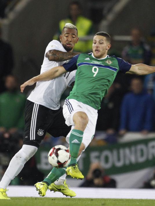 Bek Jerman, Jerome Boateng, berebut bola dengan striker Irlandia Utara, Conor Washington, pada laga Kualifikasi Piala Dunia 2018 di Stadion Windsor Park, Kamis (5/10/2017). Jerman menang 3-1 atas Irlandia Utara. (AP/Peter Morrison)