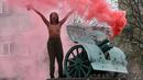 Seorang aktivis wanita gerakan hak perempuan Femen meneriakkan slogan-slogan di tiang monumen Soviet di pusat kota Kiev, Ukraina (7/11). Aktivis tersebut menggelar aksi memperingati 100 tahun Revolusi Bolshevik. (AFP Photo/Genya Savilov)