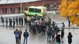 Warga berkerumun pasca terjadinya penyerangan di sebuah sekolah di Trollhattan, Swedia barat, Kamis (22/10). Seorang murid dan guru tewas akibat diserang pria bertopeng dan bersenjatakan pedang. (REUTERS/Bjorn Larsson Rosvall/TT News Agency)