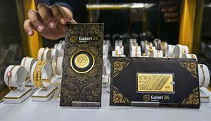 Salah satu karyawan memperlihatkan lembaran emas yang dipajang di Galeri 24, Surabaya, Jawa Timur, pada Kamis 16 Oktober 2025. (Juni KRISWANTO/AFP)