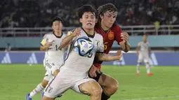 Pemain Timnas Spanyol U-17, Andres Cuenca (kanan) membayangi pergerakan pemain Jepang U-17, Alen Inoue dalam pertandingan babak 16 Besar Piala Dunia U-17 di Stadion Manahan, Solo, Senin (20/11/2023). (Bola.com/Arief Bagus)