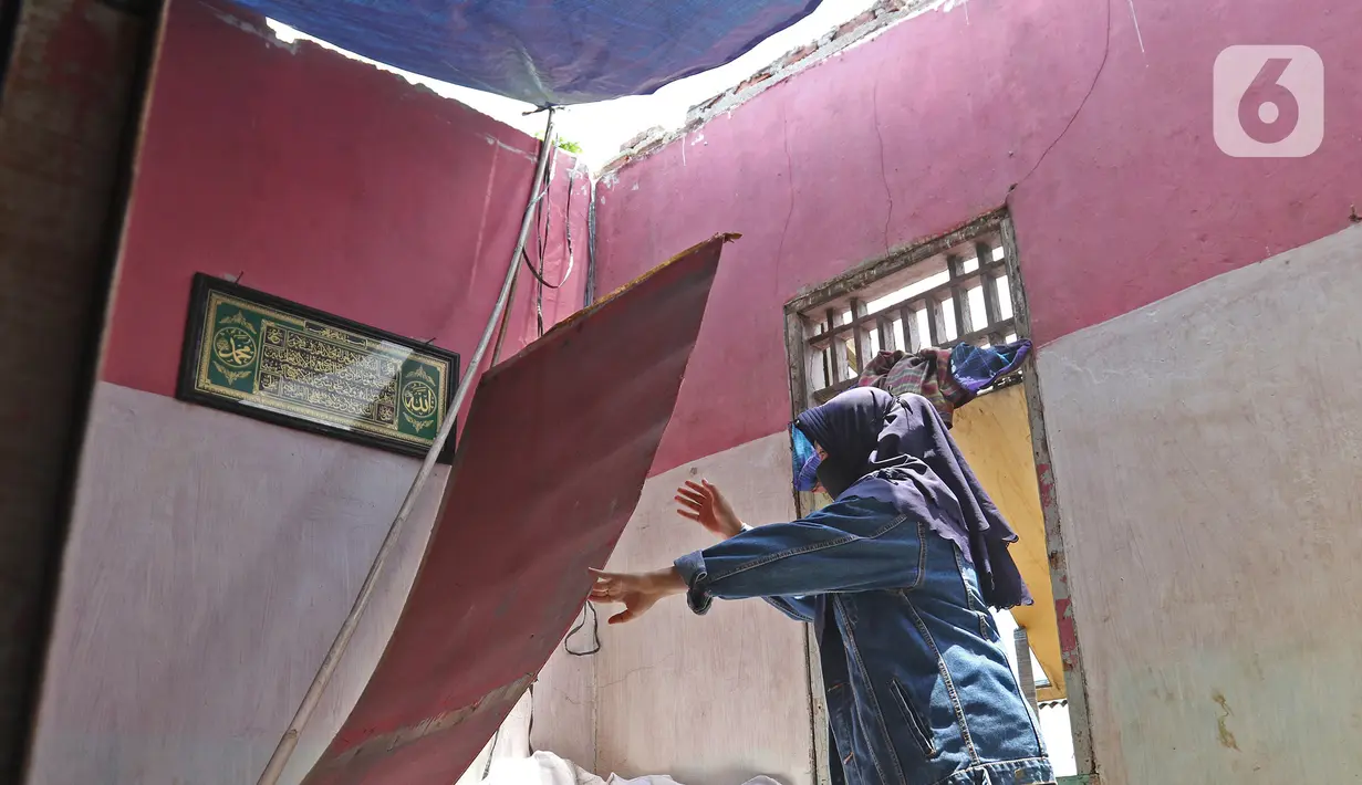 Warga berada di dalam bangunan rumah yang rusak diterjang angin puting beliung di Kaliabang Tengah, Kota Bekasi, Sabtu (24/10/2020). Menurut Badan Penanggulangan Bencana Daerah (BPBD) sebanyak 159 rumah terdampak puting beliung yang terjadi Jumat siang. (Liputan6.com/Herman Zakharia)