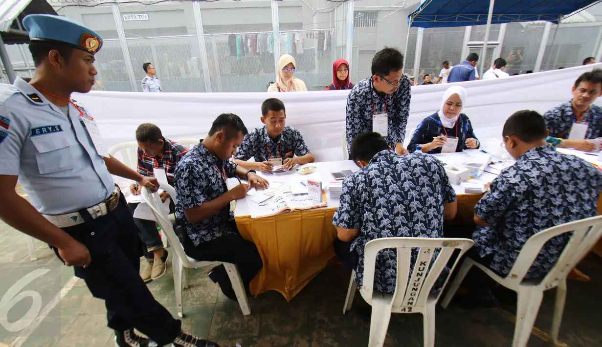 Petugas TPPS menyiapkan surat suara jelang pemungutan suara di TPS 28 Lembaga Pemasyarakatan Klas 1 Narkoba, Salemba, Jakarta, Rabu(15/2). Paslon nomor urut 2 mengungguli dengan total suara 77 suara. (Liputan6.com/Helmi Afandi)