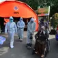 Petugas mengevakuasi pasien COVID-19 untuk menjalani perawatan di dalam tenda darurat di RSUD Kota Bekasi, Jumat (25/06/2021). Puluhan pasien covid-19 saat ini dirawat dalam tenda darurat karena keterisian tempat tidur yang penuh akibat lonjakan kasus. (merdeka.com/Arie Basuki)