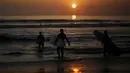 Wisatawan sedang bersiap untuk berselancar saat matahari terbenam di sebuah pantai di La Serena, Chile, Selasa (23/5/2015). (REUTERS/Marcos Brindicci)