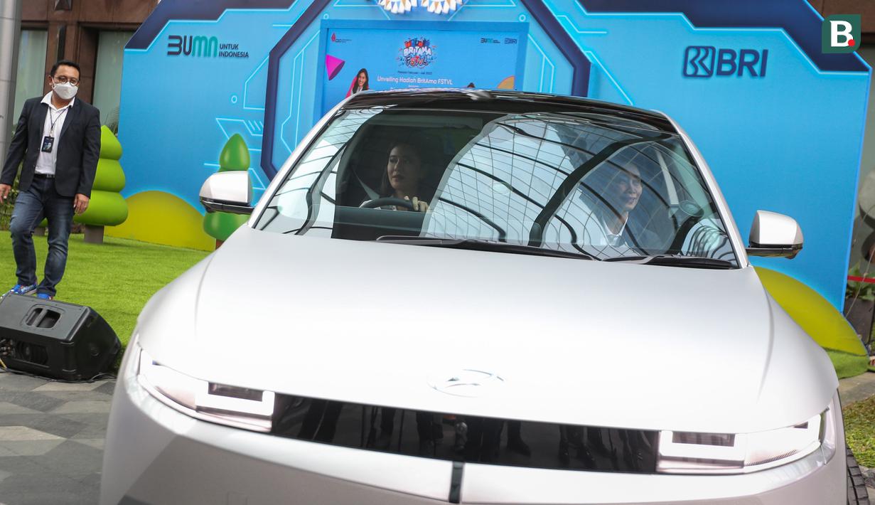 Dian Sastrowardoyo (kiri) dan Direktur Bisnis Konsumer BRI, Handayani mencoba mobil listrik Hyundai IONIQ 5 pada acara Unveiling Ceremony Program BritAma FSTVL di depan Gallery ATM Kantor Pusat BRI, Jakarta Pusat, Jumat (01/04/2022). (Bola.com/Bagaskara Lazuardi)